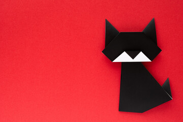 black origami cat on red background
