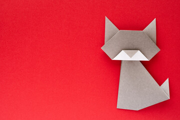 gray origami cat on red background - obrazy, fototapety, plakaty