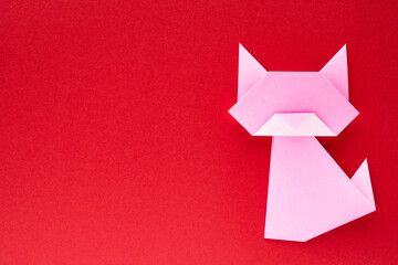 pink origami cat on red background