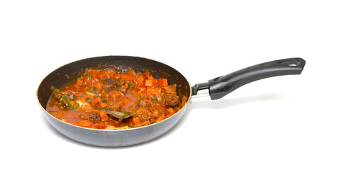 Frying pan with tomato frying isolated on a white background.