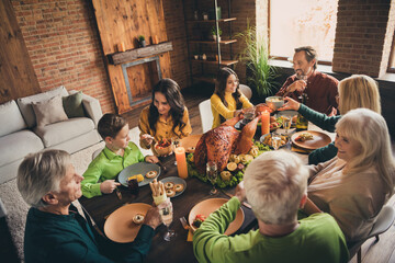 Above high angle view of nice attractive adorable cheerful family parents grandparents sitting around served table eating homemade dishes at modern loft brick industrial interior house indoors