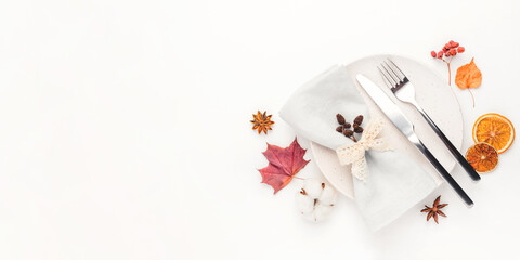 Fototapeta na wymiar Thanksgiving autumn background. Plate with Cutlery and napkin decorated with autumn leaves, berries and spices. Top view.