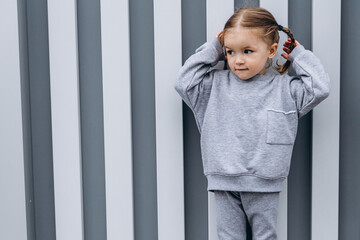portrait of a little happy girl with a sincere smile photographed in the middle of the city streets