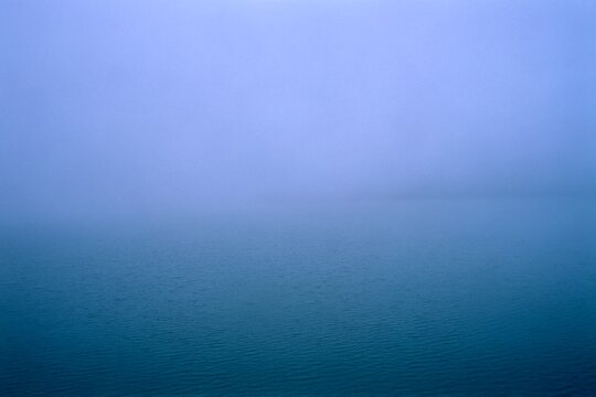 Blue rippled surface or the artificial Paltinu Lake during a misty autumn day in the Doftana Valley in Romania