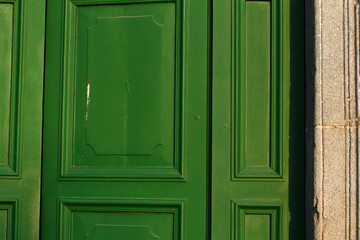 Green wooden door of the Basilica of the Holy Sepulcher in Acquapendente Lazio Italy.