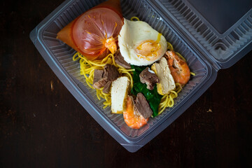 Mee Bandung Muar in a take out box, a Malaysia delicacy noodle originated from Muar District, Johore, Malaysia. The Noodle is a mixed of prawn, meat and seafood. Home delivery service.
