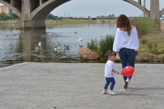 Mother and little girl enjoying in the park
Mother and her daughter enjoying a beautiful day in the field and watching the ducks in the river.
Family and mother's day concept.