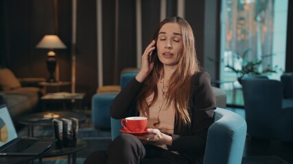 Businesswoman talking mobile phone in lobby hotel. Business woman calling phone