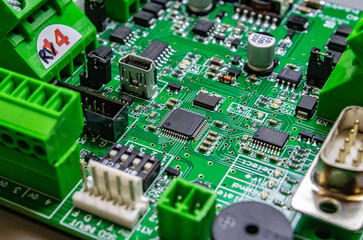 green circuitboard with microcontroller in centre of small city