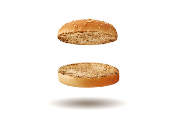 Flying, baked or grilled, cut in half burger bun sprinkled with sesame seeds. Isolated on white. Cooking and fast food. Close-up, copy space
