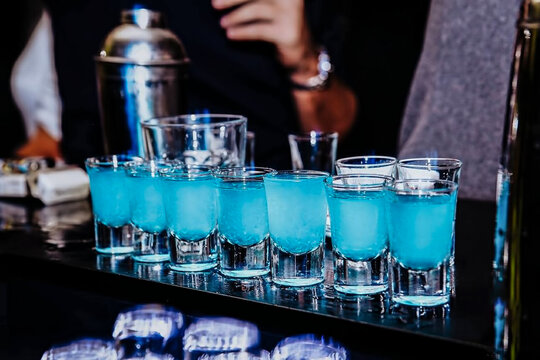Barman preparing colorful alcoholic cocktails at the club 