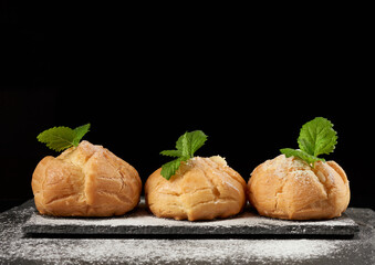 baked custard eclairs and sprinkled with powdered sugar and decorated with a mint leaf