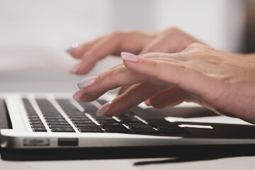 Female hands typing text on laptop computer, searching information in social networks, female keyboarding text using netbook for chatting. Concept remote work, technology. High quality photo