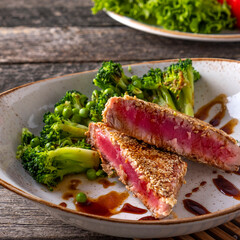 Fried tuna with vegetables on a plate in rustic style