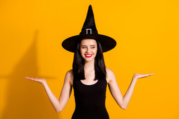 Photo of lovely charming young magician lady open palms hold empty space cunning look presenting...