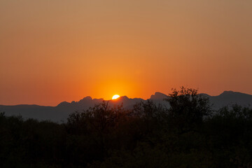 An orange desert sunrise over jagged mountains
