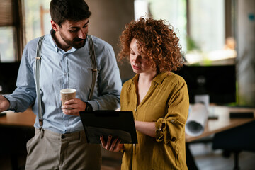  Businesswoman and businessman discussing work in office. Two friends in working together.