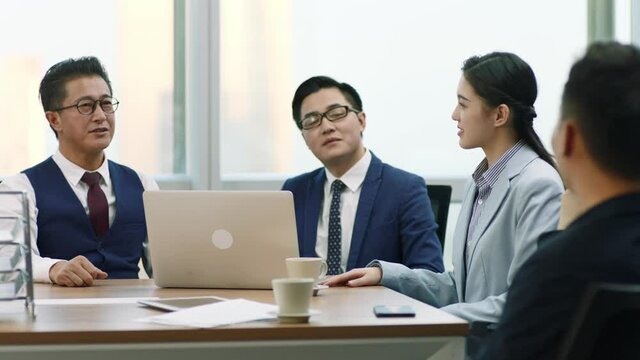 asian boss introducing new team member to colleagues and coworkers during staff meeting in modern office
