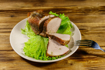 Tasty baked pork with spices on a wooden table