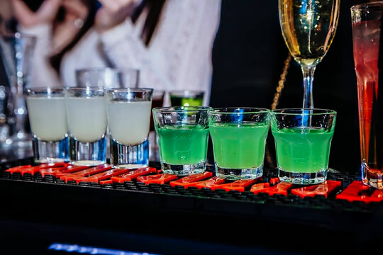 Barman preparing cold, tasty and colorful cocktails at the club 
