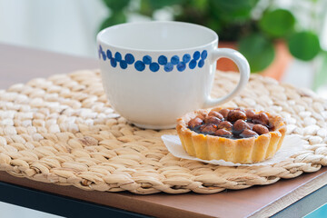 light mug and walnut cake on a wooden table