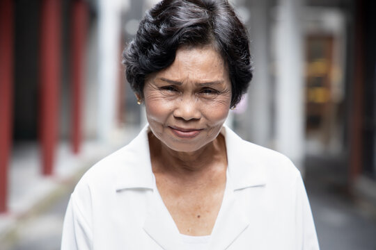 Portrait Of Angry Upset Unhappy Old Asian Senior Woman With Wrinkle Skin And Dyed Black Hair