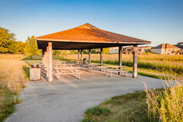 these picnic tables in a pavilion are common gathering places in the summer
