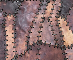 Leather patchwork. Pieces of leather stitched together with leather threads.