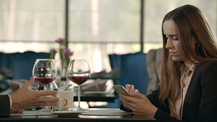 Upset businessman talking with business woman in restaurant