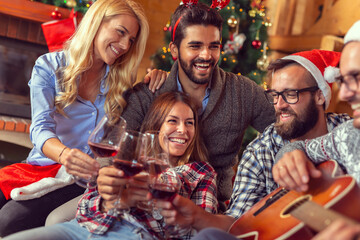 Friends playing Christmas songs on the guitar