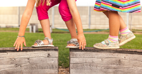 Children overcome hurdles and balance on wooden slats. Children do balance exercises in the...