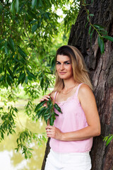 young pretty woman posing cheerful outside in green park, lifestyle people concept