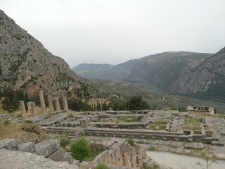 Fototapeta na wymiar Ruined ancient sanctuary Delphi, also called Python, in Greece in summer. The?ancient Greeks?considered the centre of the world to be in Delphi, marked by the stone monument known as?the omphalos.