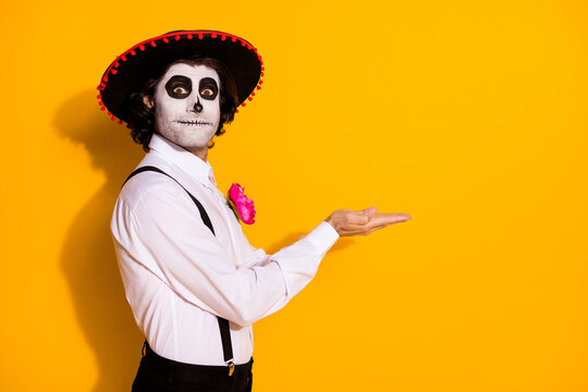 Profile photo of creepy ghost guy hands hold empty space propose handmade potion limited edition wear white shirt rose sugar skull death costume suspenders isolated yellow color background