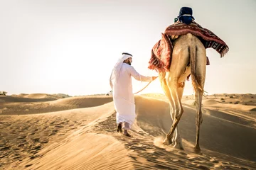 Fotobehang Arabische man met kameel in de woestijn © oneinchpunch