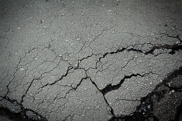 Crack on asphalt close-up with sunlight, texture