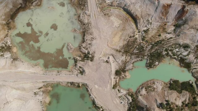 Drone view on a flooded kaolin quarry with turquoise water and white shore. Aerial survey of a kaolin pit flooded with water.