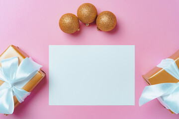Christmas festive mock up with blank page, wrapped gifts and baubles on pink