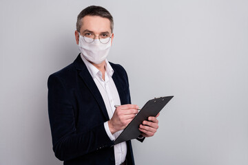 Profile side view portrait of his he content skilled mature guy wearing safety mask writing document syndrome disease insurance assistance stop mers cov pandemia isolated light gray color background