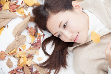 Obraz na płótnie Canvas 落ち葉に寝転ぶ女性