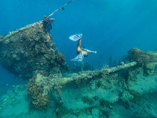 Freediving man enjoying shipwreck