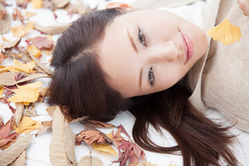 Obraz na płótnie Canvas 落ち葉に寝転ぶ女性