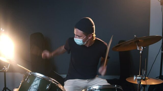 Music studio room. Man playing drums. Life of musicians during the coronavirus. The caucasian male person keeping a distance during the COVID-19 times. 