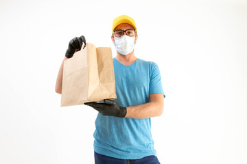 Fototapeta na wymiar Delivery guy with protective mask holding paper bag with groceries.