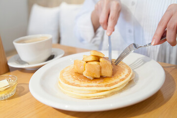 カフェでパンケーキを食べる女性