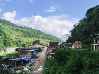 A small housing in between two green hills with beautiful scenery