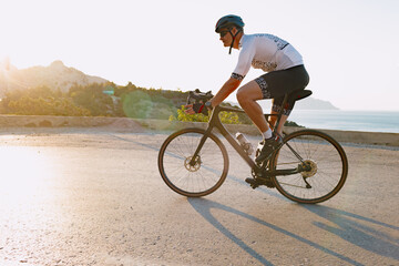 Naklejka premium Cycling sport athlete man riding on coastal road
