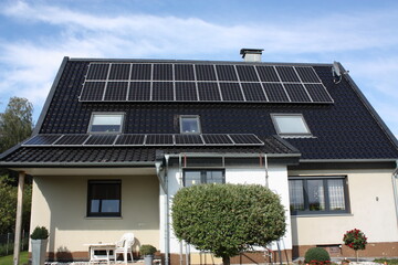 Fototapeta premium Photovoltaikanlage auf einem Haus, bei blauem Himmel und Sonnenschein, in Lippetal Büninghausen an der Buschstraße