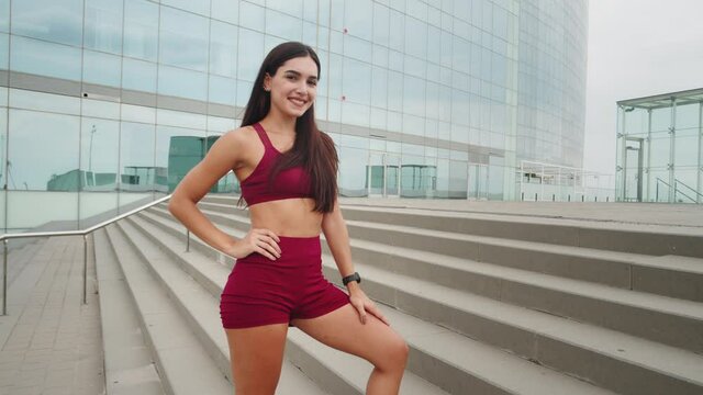 Smiling fitness young woman outdoors in the city. Sportswear, smile. Fitness trainer after training, workout in park. Sporty hispanic girl. Latin american female athlete.