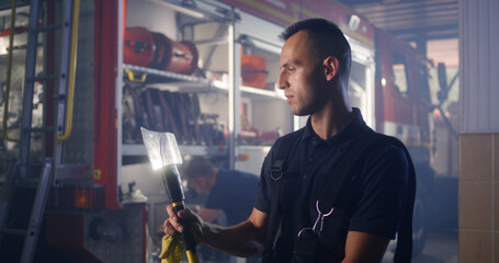 Fireman cleaning axe during work